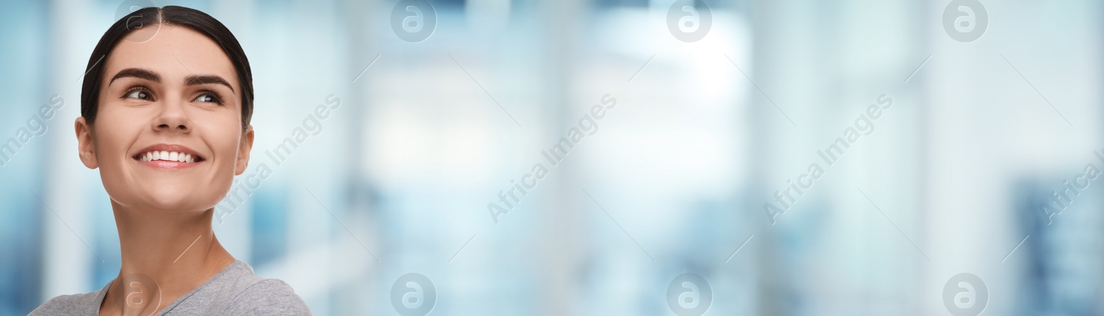 Image of Woman with clean teeth smiling on blurred background, space for text. Banner design