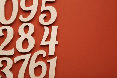 Photo of Wooden numbers on brown background, flat lay with space for text