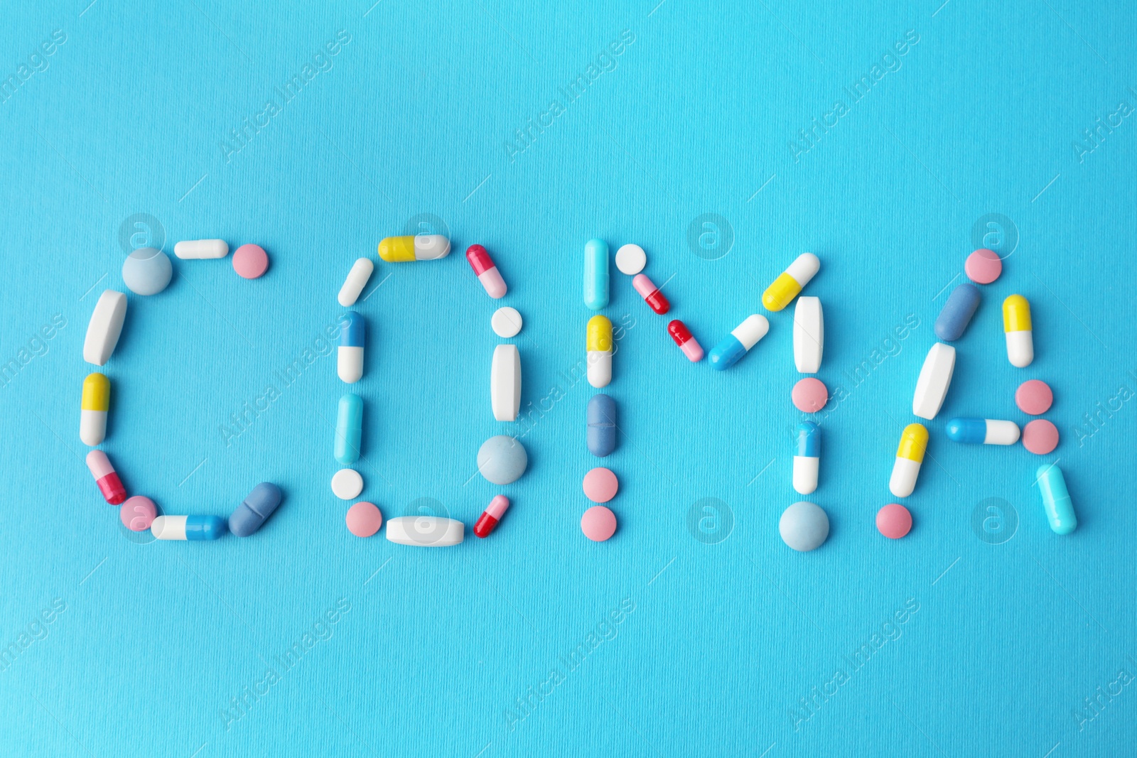 Photo of Word Coma made of pills on light blue background, flat lay