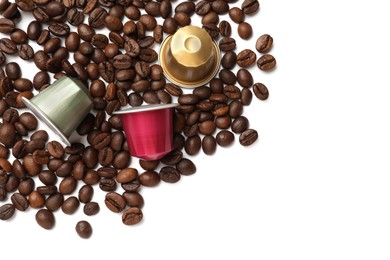 Photo of Many coffee capsules and beans on white background, top view. Space for text