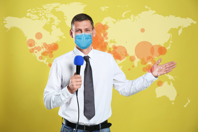 Image of Journalist with medical mask presenting news during coronavirus outbreak. World map demonstrating spread of disease