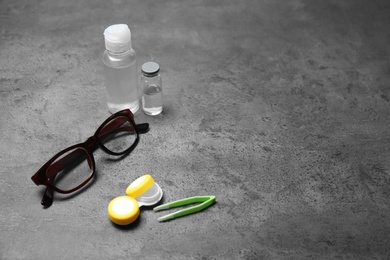 Glasses and contact lens accessories on grey background