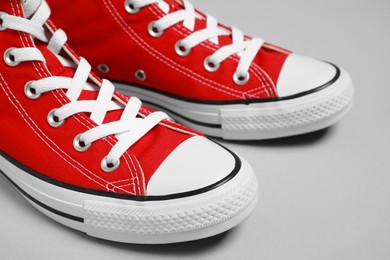 Photo of Pair of new stylish red sneakers on light grey background, closeup