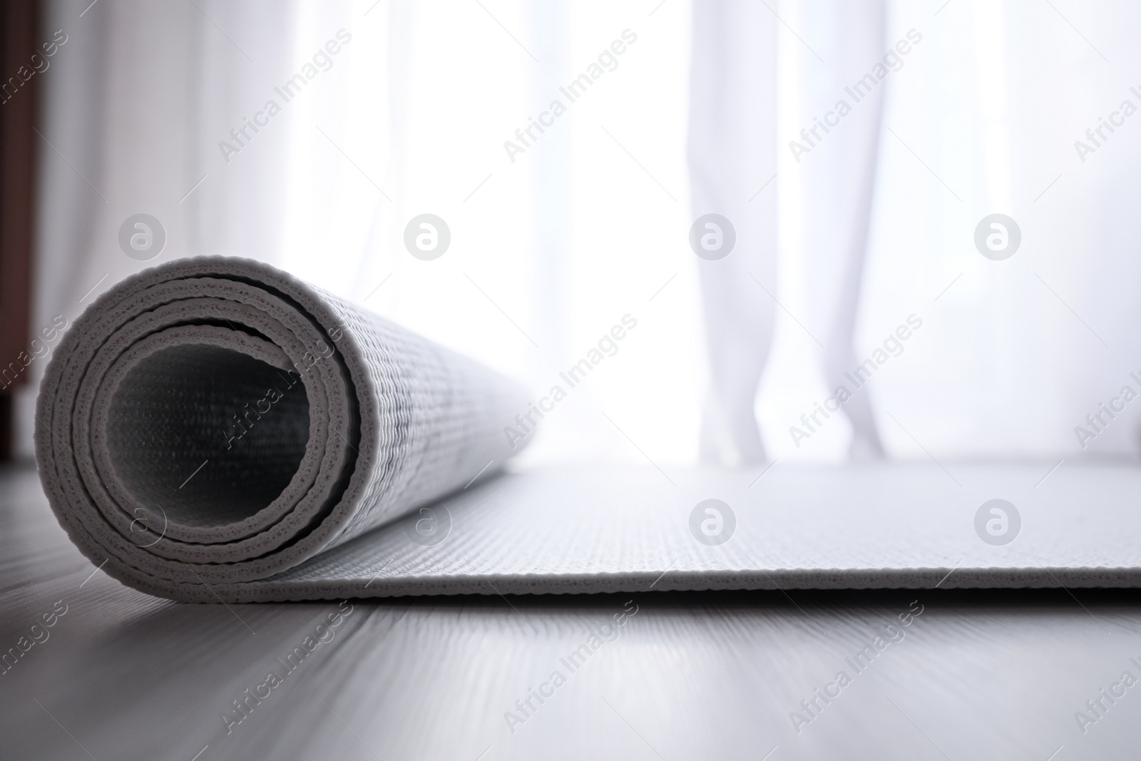 Photo of Karemat or fitness mat on wooden floor, closeup