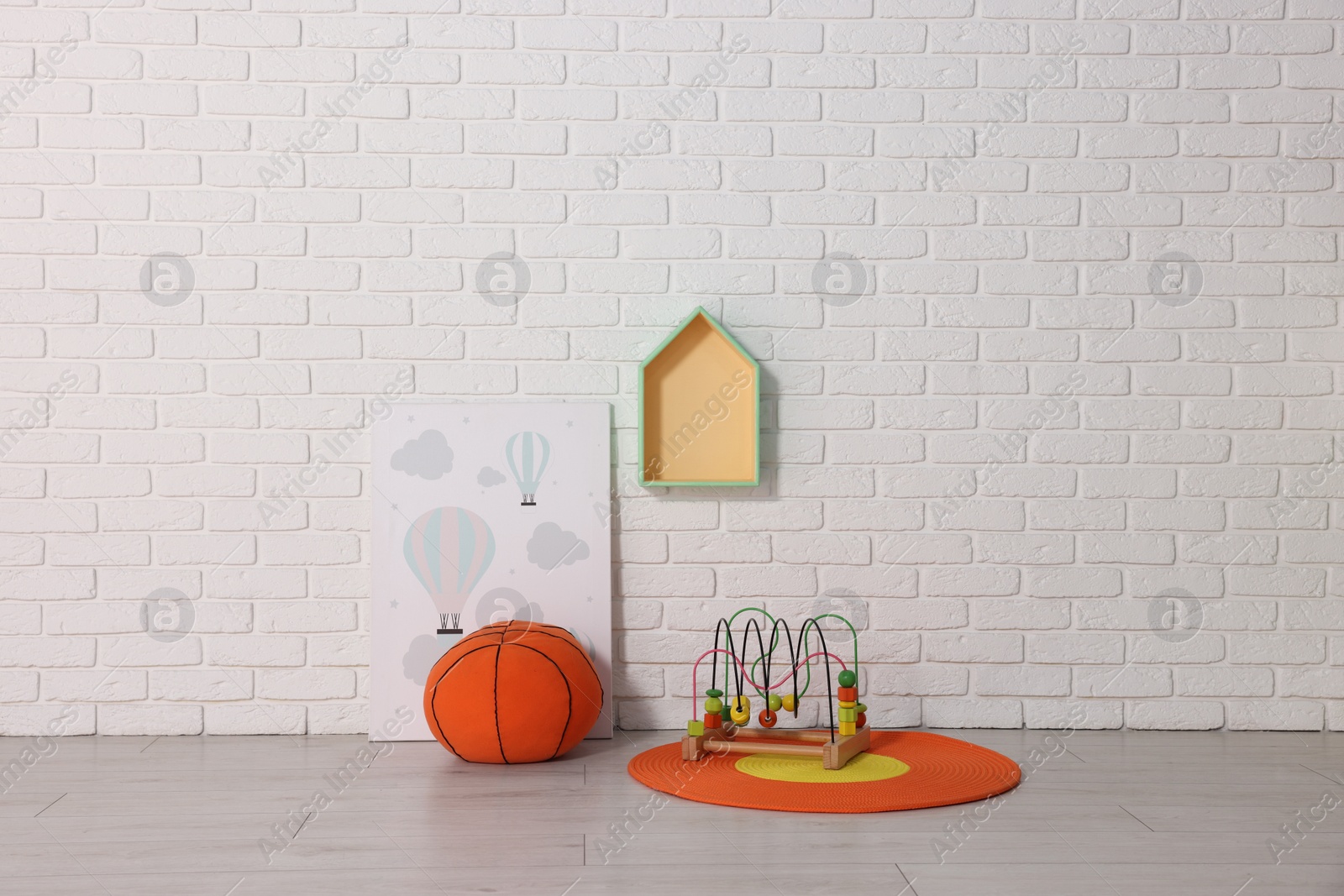 Photo of Beautiful children's room with white brick wall and toys. Interior design