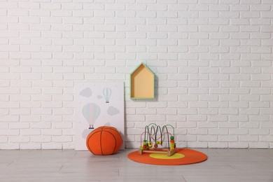 Photo of Beautiful children's room with white brick wall and toys. Interior design