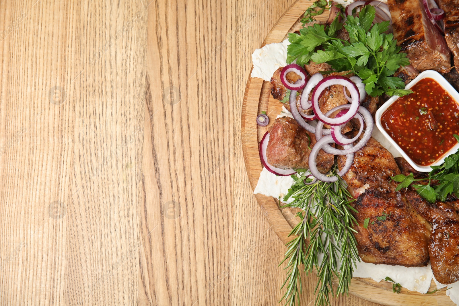 Photo of Delicious roasted meat served on wooden table, top view. Space for text