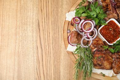 Photo of Delicious roasted meat served on wooden table, top view. Space for text