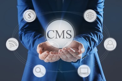 Image of CMS. Man using virtual screen, closeup. Scheme with icons on dark background