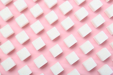 Photo of White sugar cubes on pink background, top view