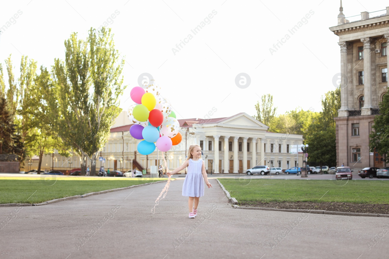 Photo of Cute little girl with colorful balloons outdoors on sunny day