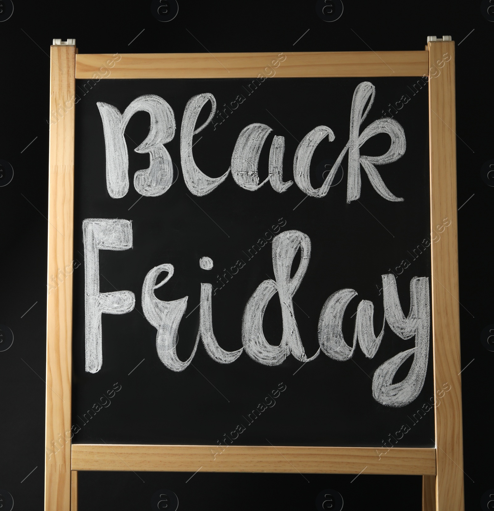 Photo of Board with phrase Black Friday on dark background