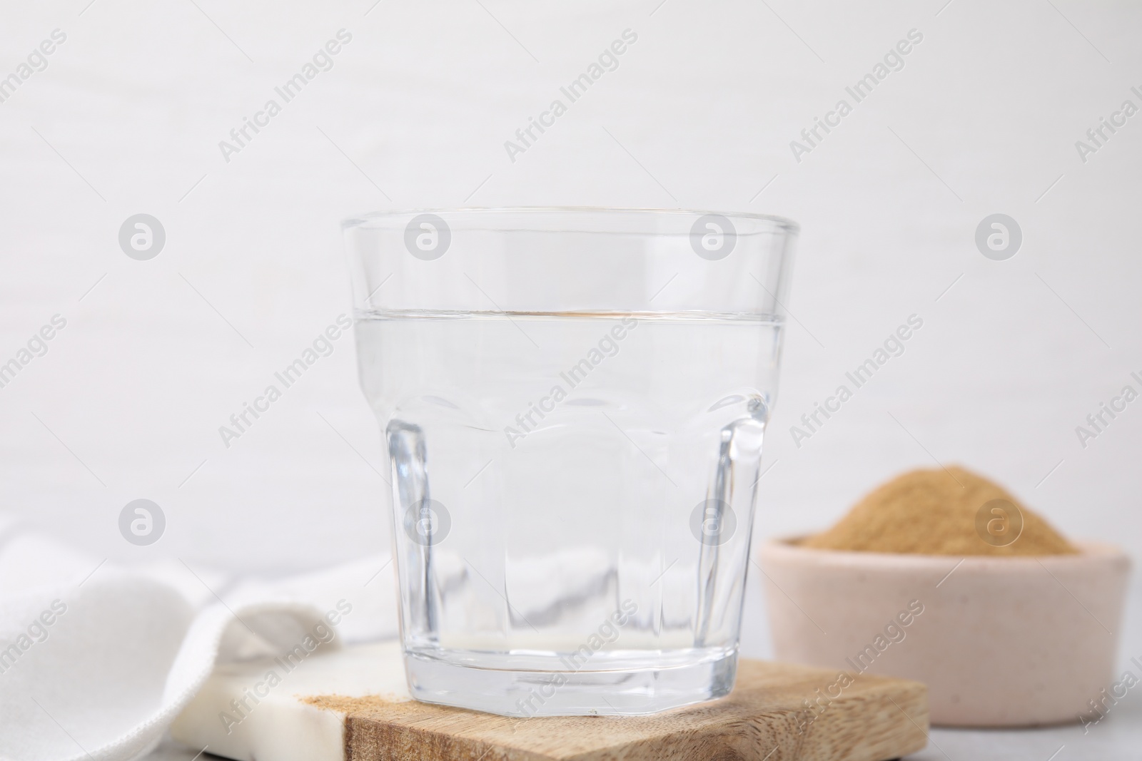 Photo of Dietary fiber. Glass of water and psyllium husk powder on table