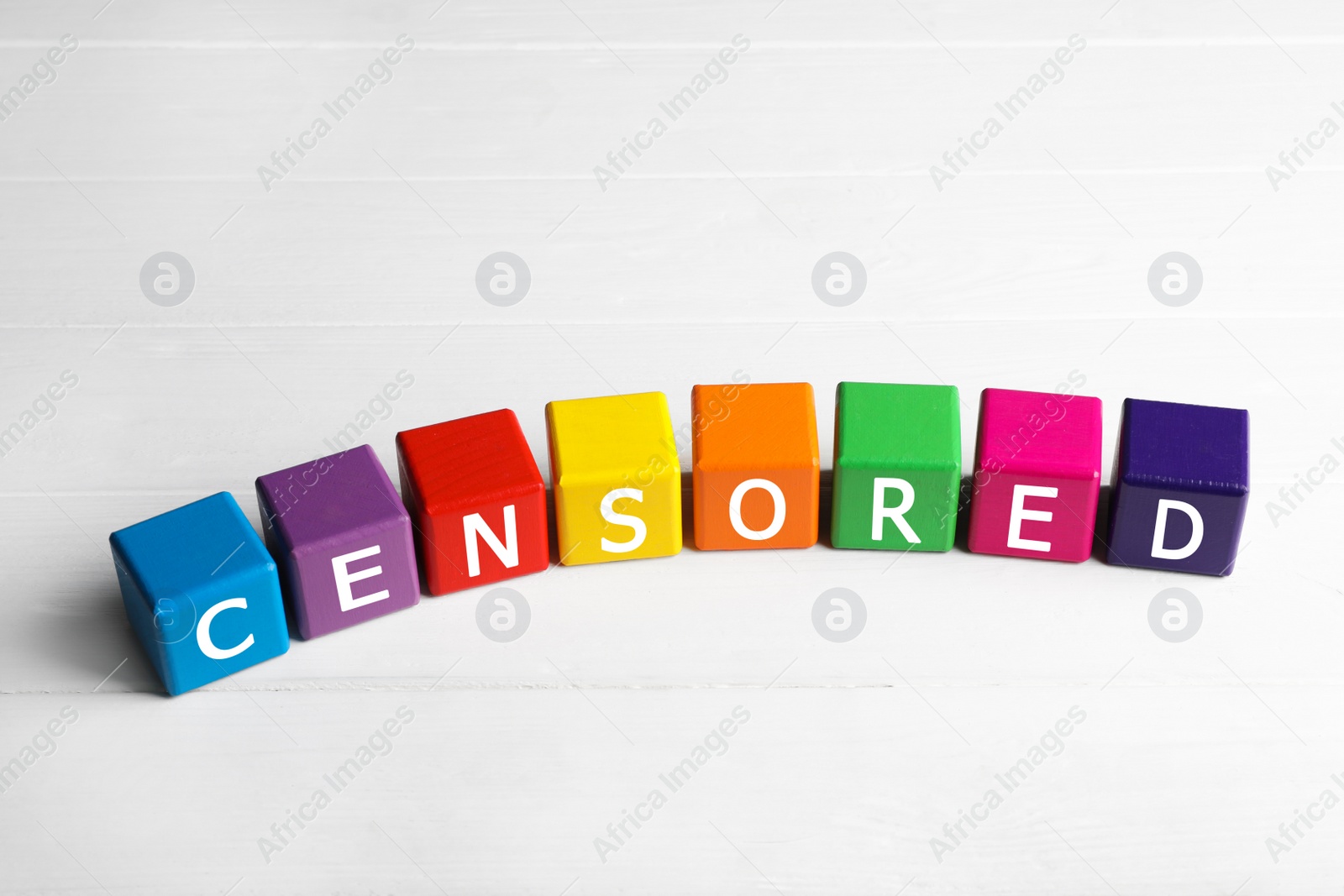 Photo of Colorful cubes with word Censored on white wooden table