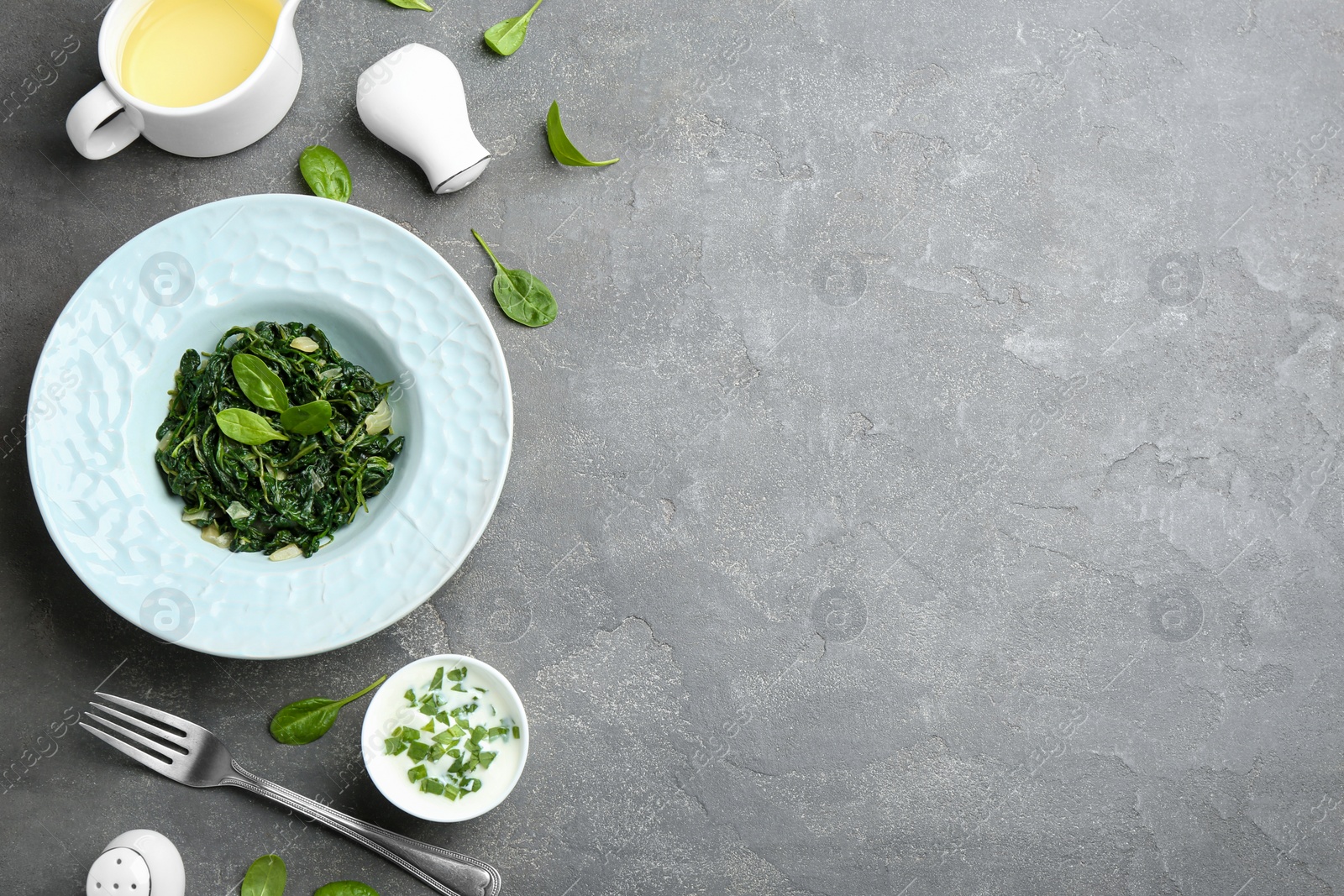 Photo of Flat lay composition of tasty spinach on grey table. Healthy food