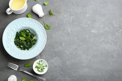 Photo of Flat lay composition of tasty spinach on grey table. Healthy food