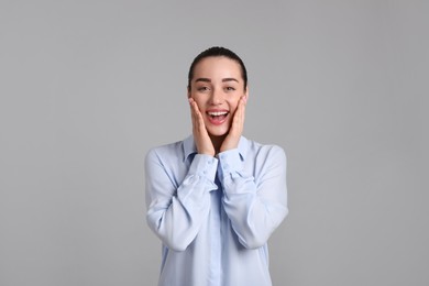 Portrait of happy young woman on light grey background. Personality concept