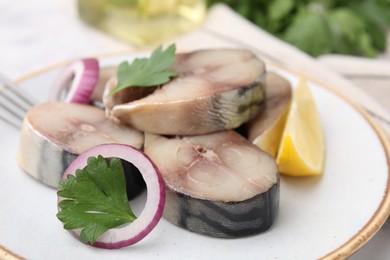 Photo of Slices of tasty salted mackerel with lemon and onion on table, closeup