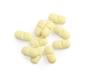 Photo of Many yellow pills isolated on white, top view