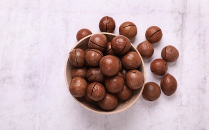 Photo of Delicious organic Macadamia nuts on light gray table, flat lay