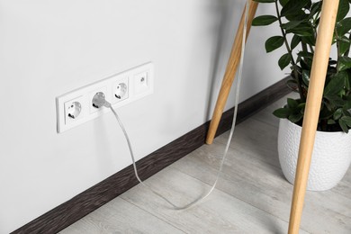 Power socket and plug on wall indoors. Electrician's equipment