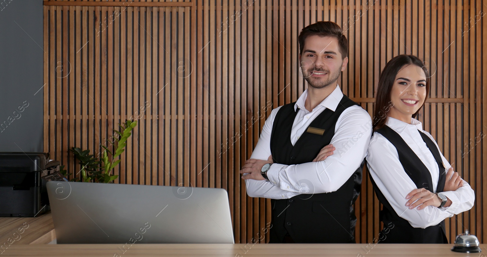 Image of Smiling receptionists at desk in modern lobby. Banner design