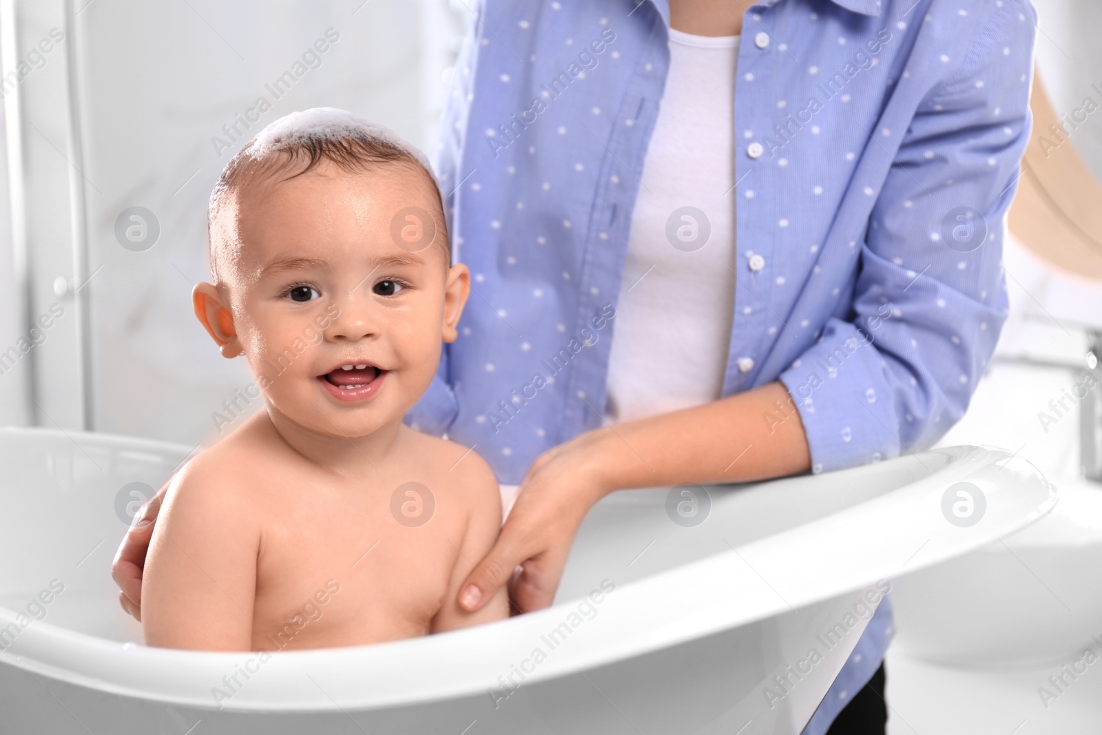 Photo of Mother with her little baby in bathroom