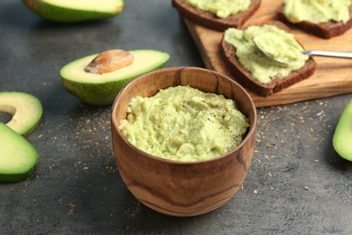 Bowl with guacamole made of ripe avocados on table