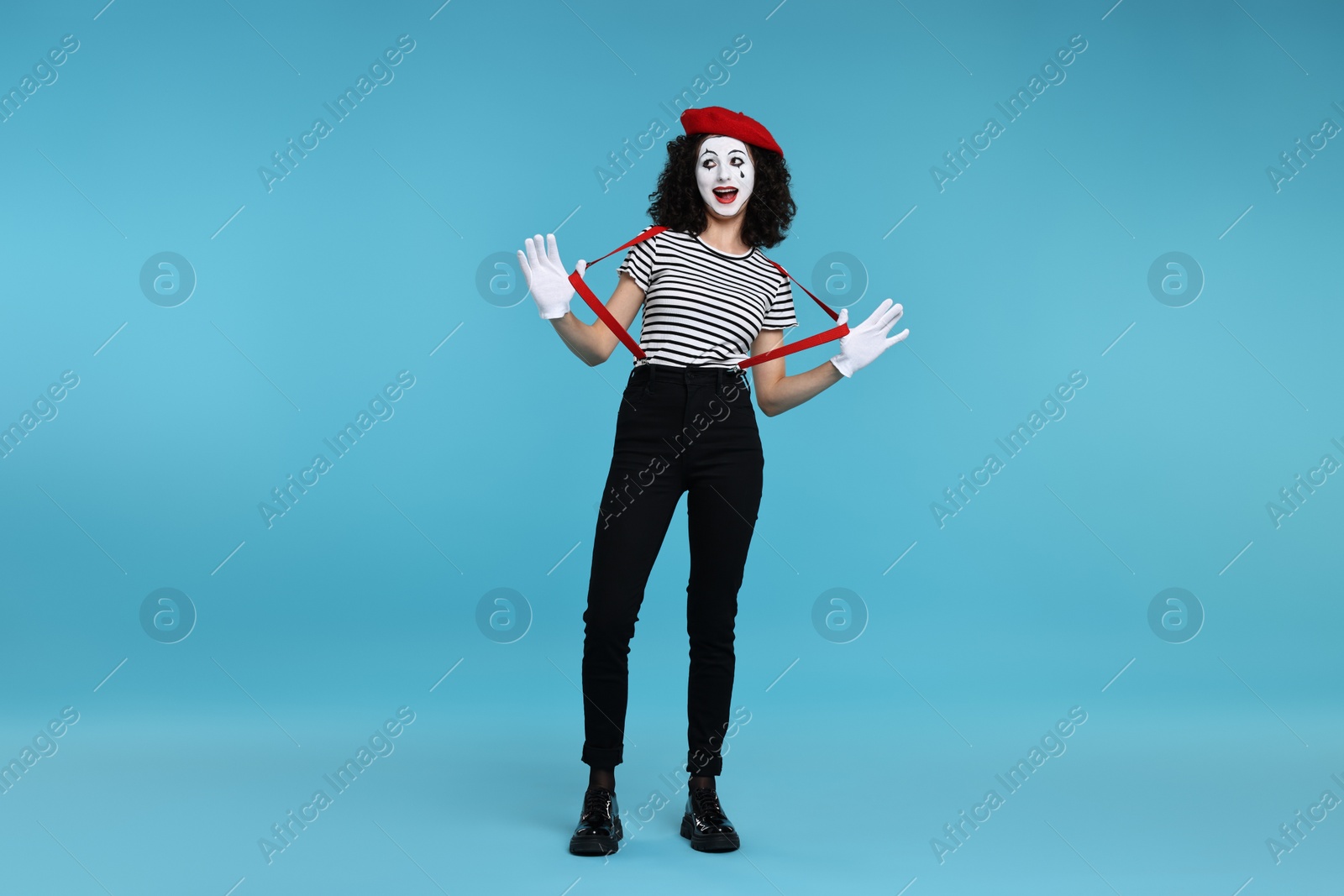 Photo of Funny mime with beret posing on light blue background