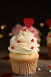 Photo of Tasty sweet cupcake on wooden table, closeup. Happy Valentine's Day