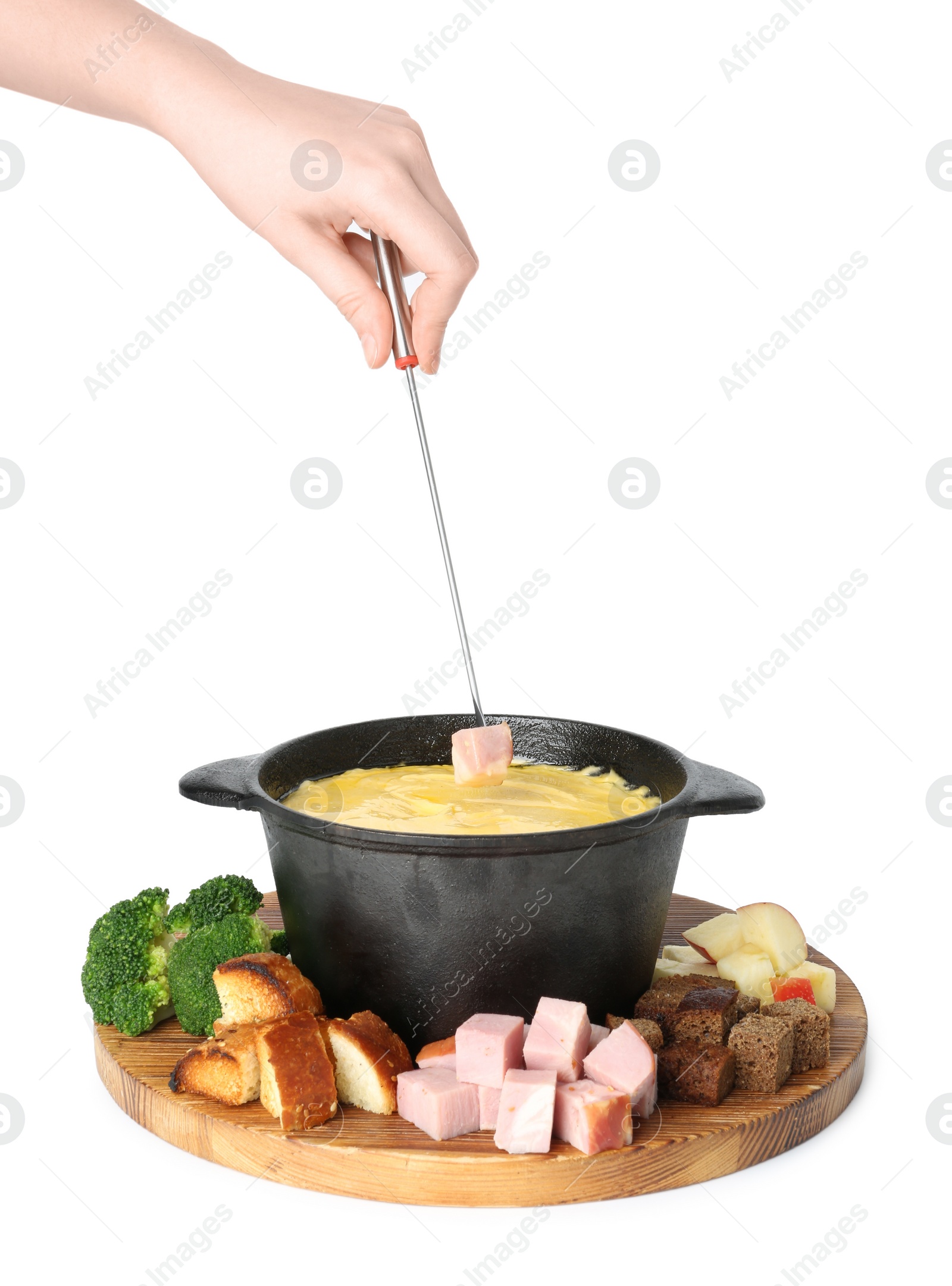 Photo of Woman dipping piece of ham into fondue pot with tasty melted cheese on white background, closeup