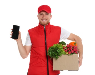 Delivery man with box of fresh vegetables and smartphone on white background, mockup for design