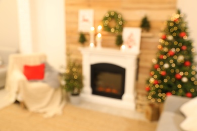 Blurred view of beautiful living room interior with burning fireplace. Christmas celebration