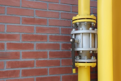 Photo of Yellow gas pipe near red brick wall outdoors, space for text
