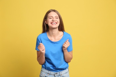 Portrait of hopeful woman on yellow background