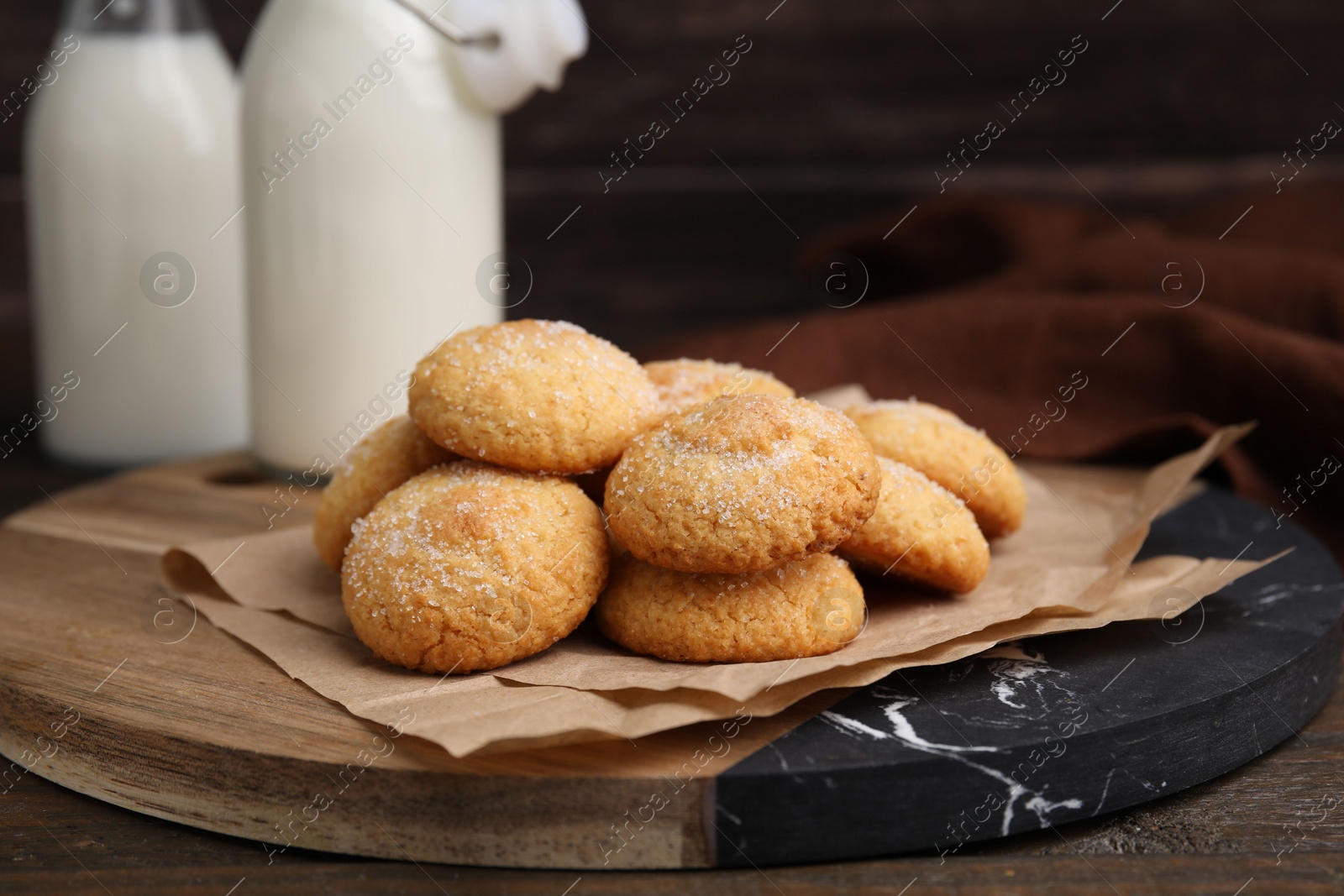 Photo of Tasty sweet sugar cookies and milk on wooden table, closeup