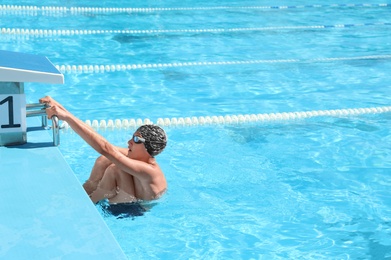 Photo of OCHAKIV, UKRAINE - JULY 09, 2020: Child getting out of outdoor pool. Summer camp "Sportium"
