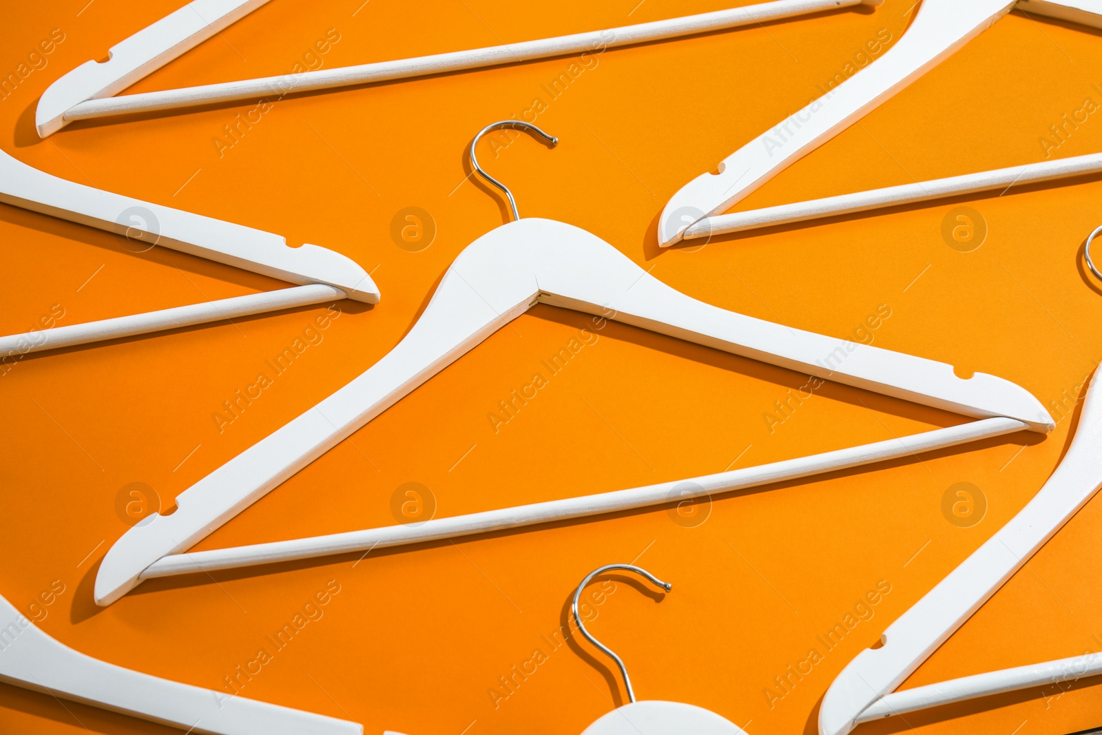 Photo of Composition with empty hangers on color background, above view