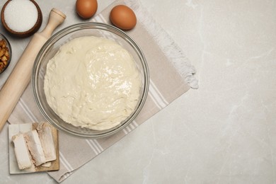 Fresh yeast dough and ingredients for cake on marble table, flat lay