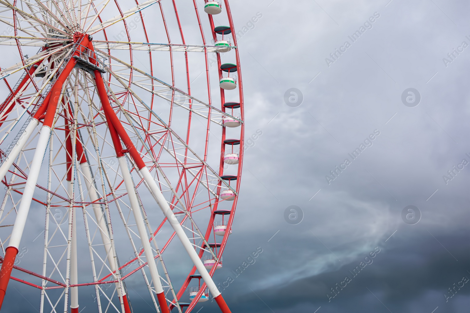 Photo of Beautiful large Ferris wheel against heavy rainy clouds outdoors. Space for text