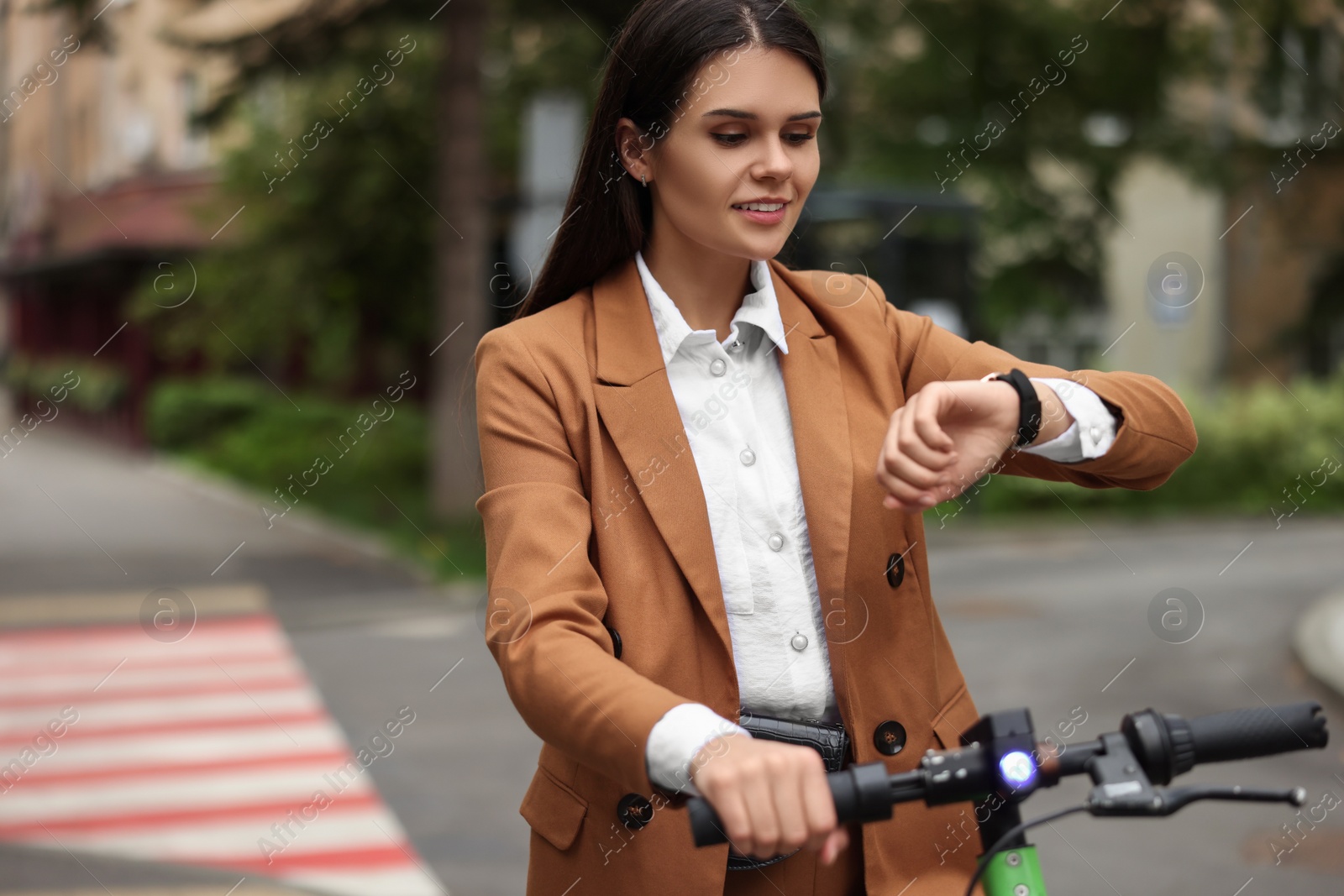 Photo of Businesswoman with modern electric kick scooter on city street, space for text