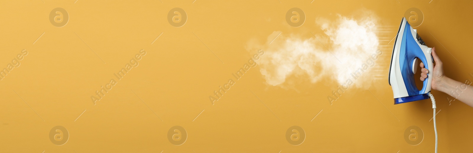 Image of Woman with iron on orange background, closeup. Banner design with space for text