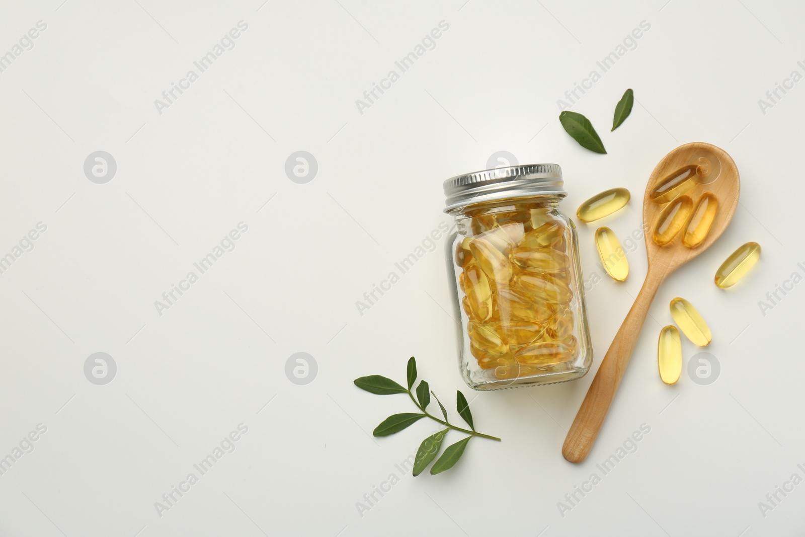 Photo of Bottle, vitamin capsules, spoon and leaves on white background, flat lay. Space for text