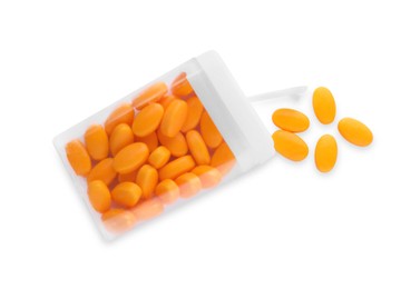 Photo of Tasty orange dragee candies in box on white background, top view