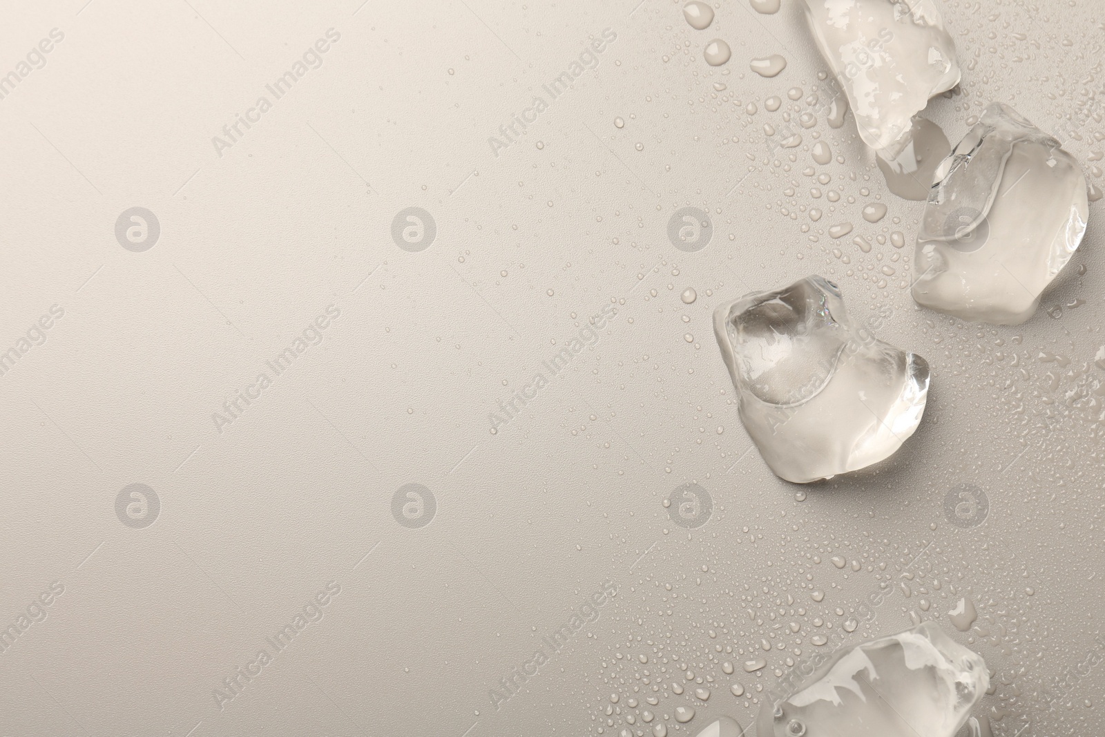 Photo of Pieces of crushed ice on grey background, top view. Space for text