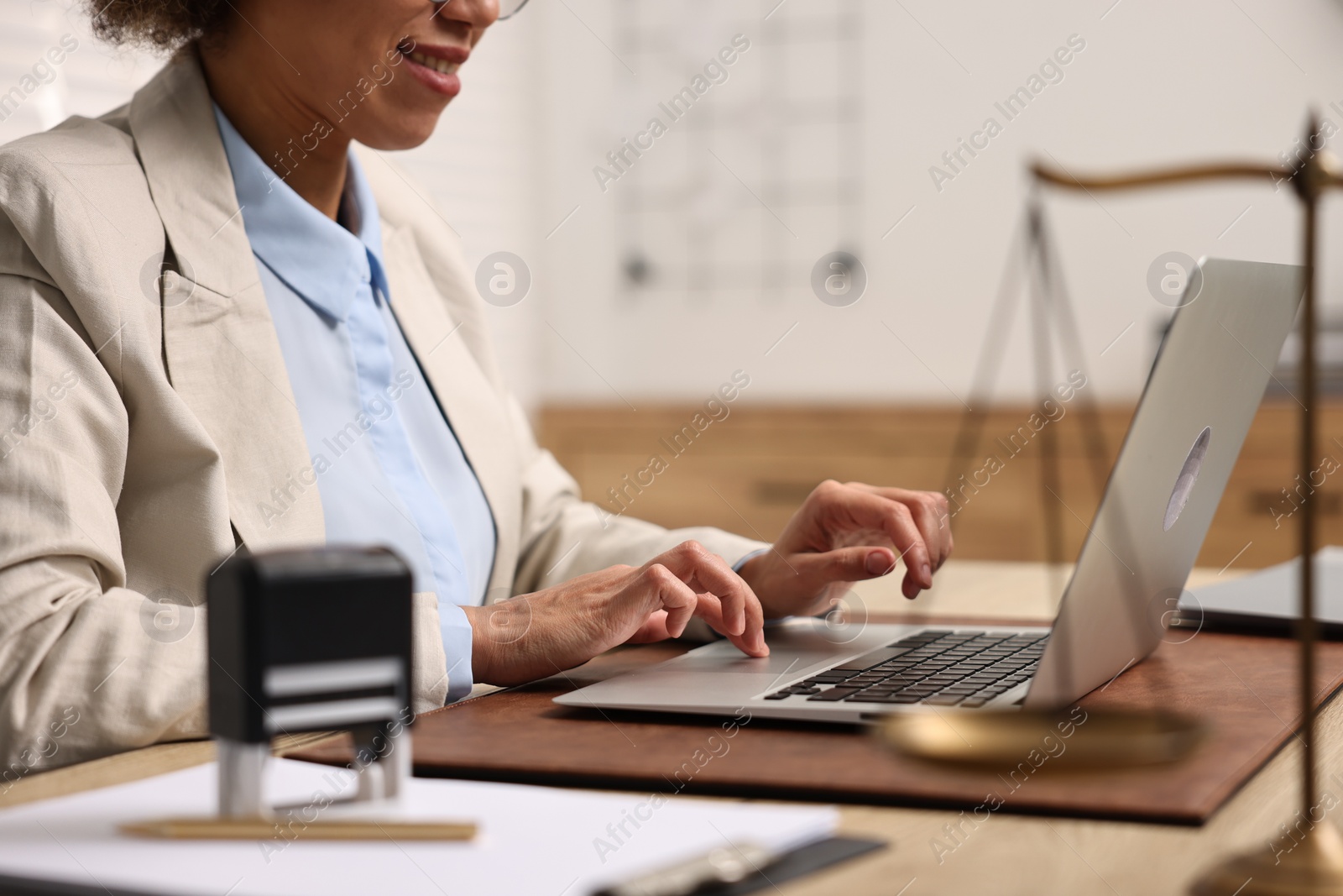 Photo of Notary using laptop at workplace in office, closeup