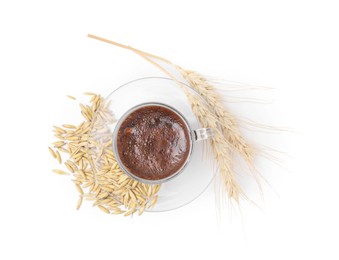 Photo of Cup of barley coffee, grains and spikes isolated on white, top view