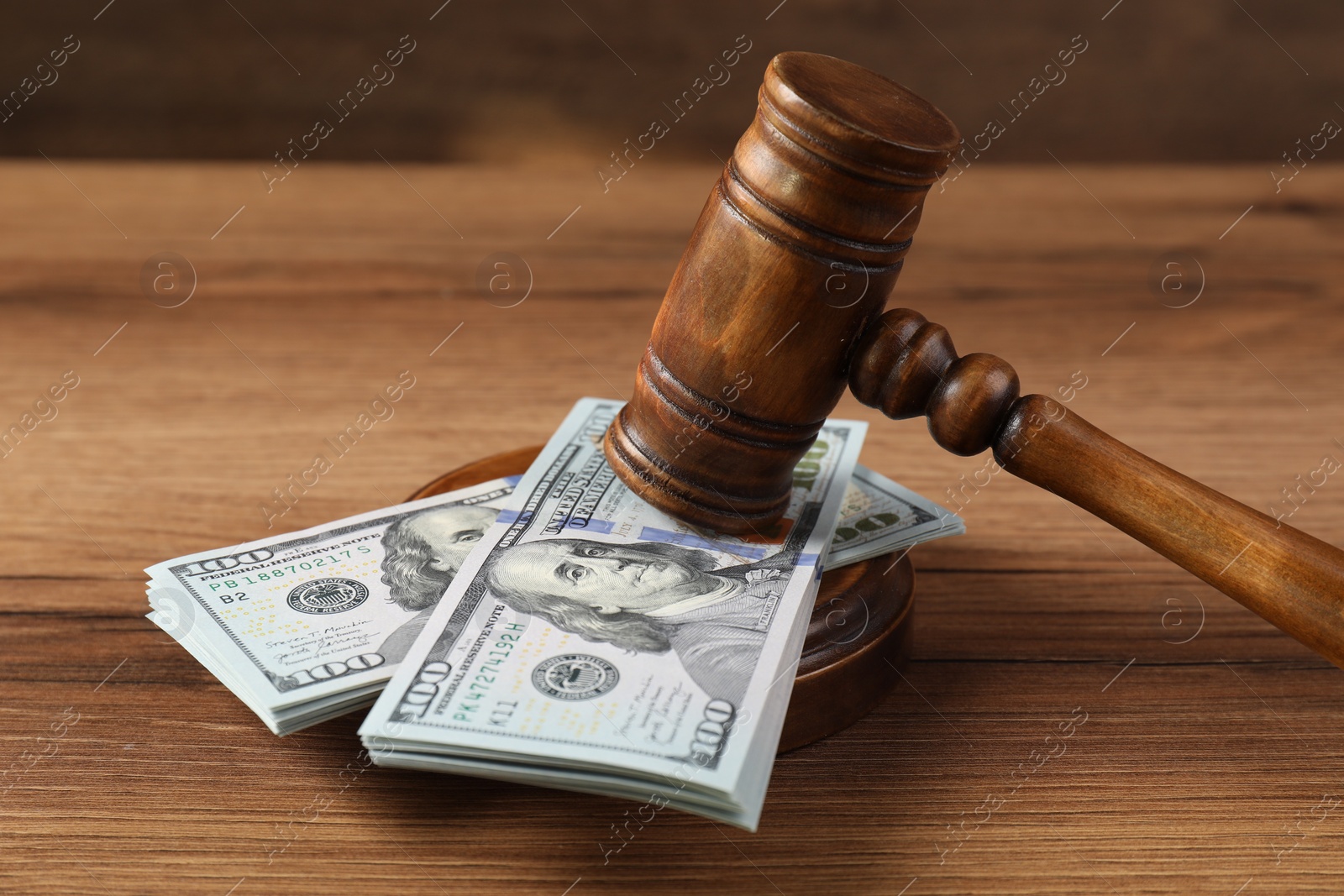 Photo of Judge's gavel and money on wooden table