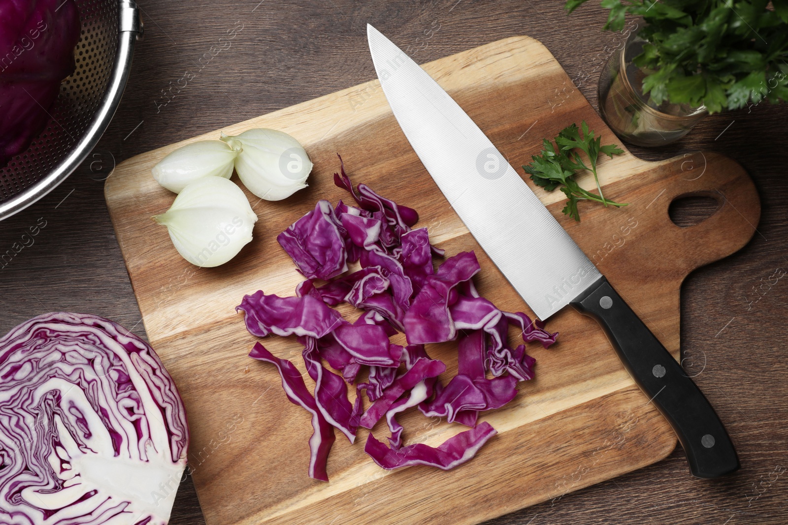 Photo of Cut fresh red cabbage and knife on wooden table, flat lay