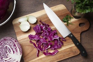 Photo of Cut fresh red cabbage and knife on wooden table, flat lay